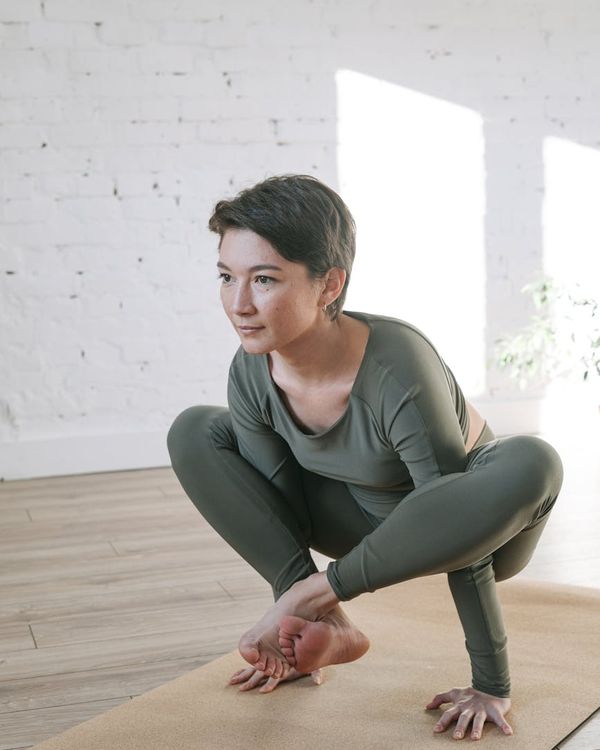 Woman in a peaceful yoga pose in a bright, calm room.